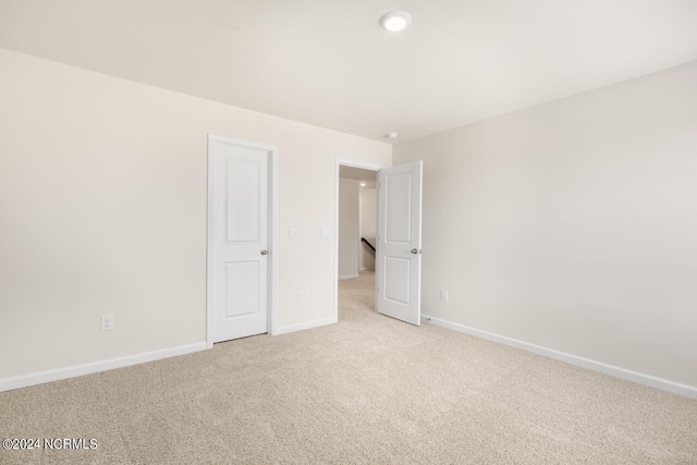 interior space with baseboards and light colored carpet