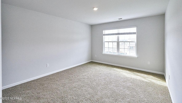 carpeted empty room with visible vents and baseboards