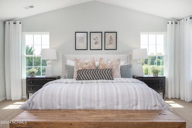 carpeted bedroom featuring visible vents, multiple windows, and lofted ceiling