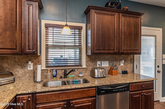 kitchen with stainless steel dishwasher, light stone countertops, backsplash, and a sink