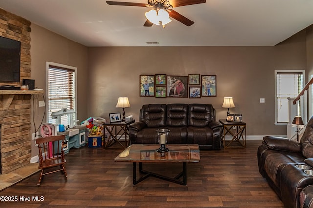 living room with visible vents, a fireplace, a ceiling fan, and wood finished floors