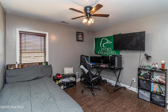 bedroom featuring ceiling fan, wood finished floors, visible vents, and baseboards