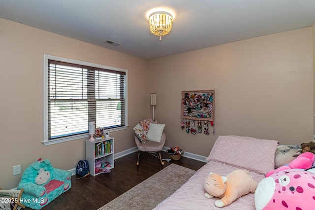 bedroom with wood finished floors, visible vents, and baseboards