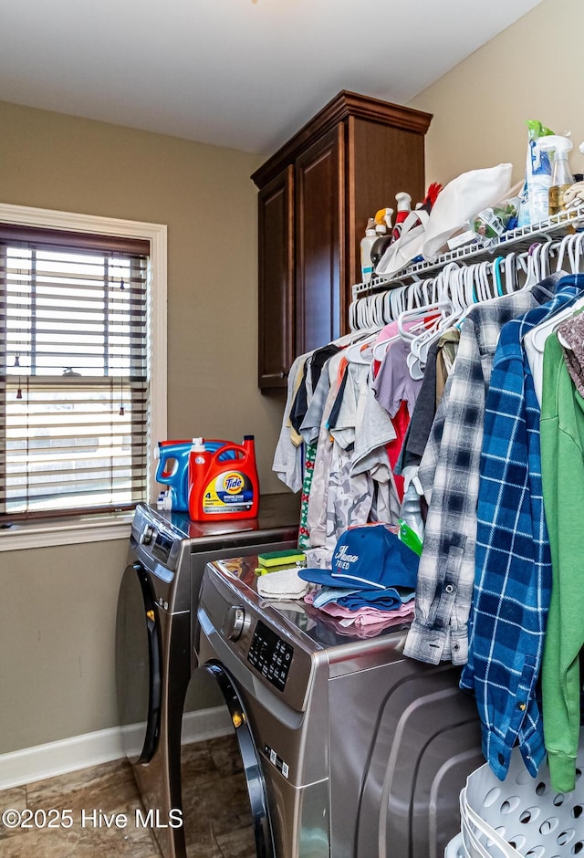 laundry room with cabinet space, baseboards, and washer and clothes dryer