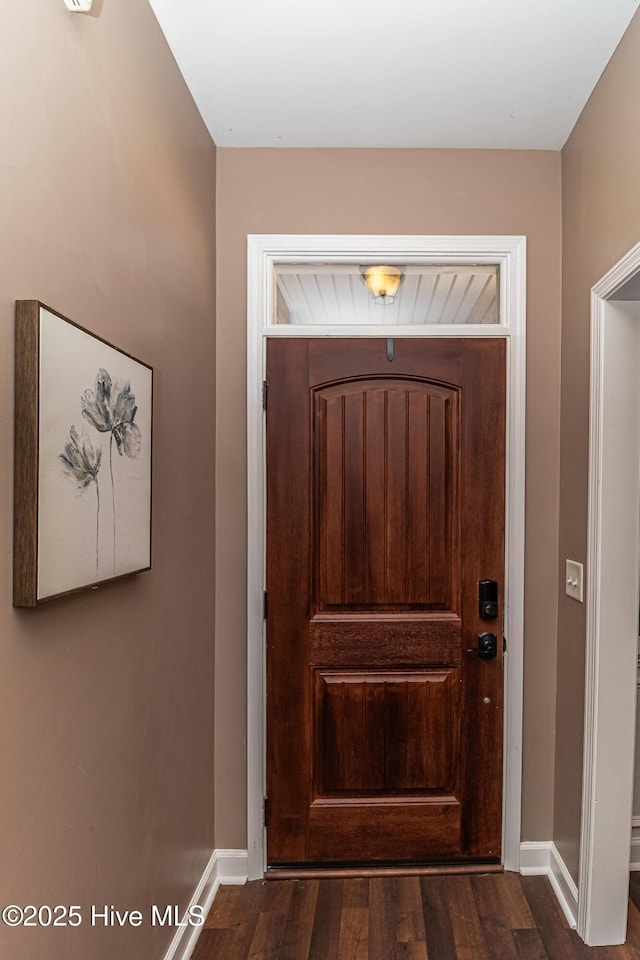 doorway with baseboards and dark wood-style flooring