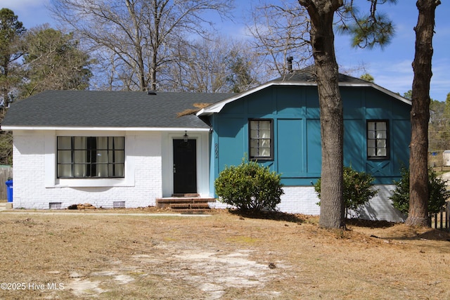 view of front of house with crawl space, brick siding, and a shingled roof