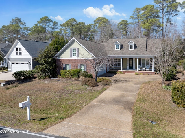 new england style home featuring a garage, brick siding, covered porch, and concrete driveway