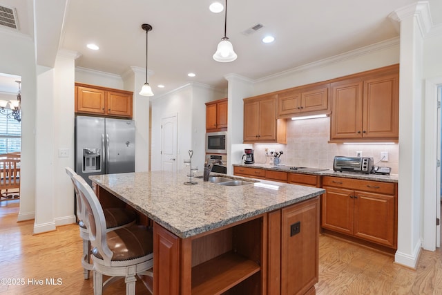 kitchen featuring visible vents, brown cabinets, stainless steel appliances, and light wood-style floors