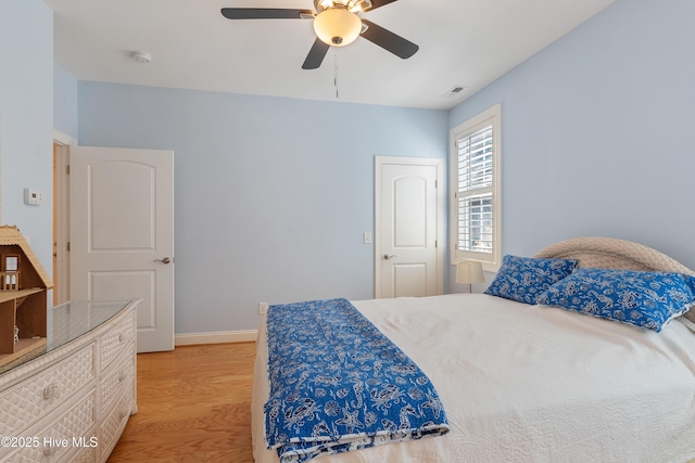 bedroom featuring visible vents, baseboards, light wood-style floors, and a ceiling fan