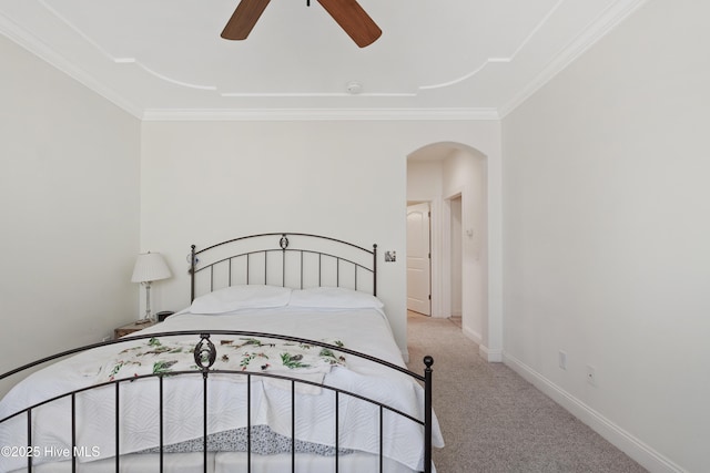 carpeted bedroom with baseboards, arched walkways, ceiling fan, and crown molding