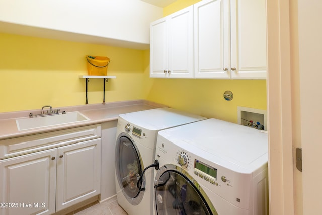 clothes washing area featuring a sink, cabinet space, and washer and clothes dryer