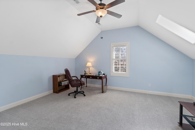 home office featuring visible vents, baseboards, carpet flooring, vaulted ceiling with skylight, and a ceiling fan