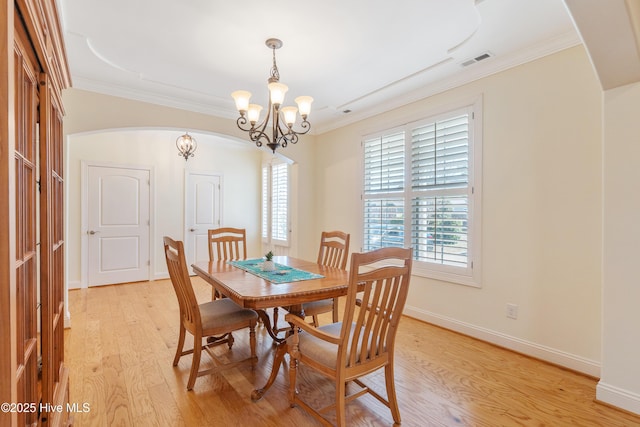 dining room featuring visible vents, ornamental molding, light wood finished floors, baseboards, and a chandelier