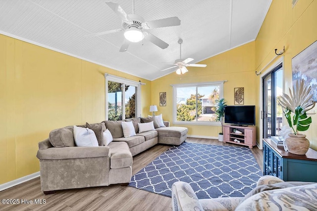 living area with vaulted ceiling, wood finished floors, baseboards, and ceiling fan