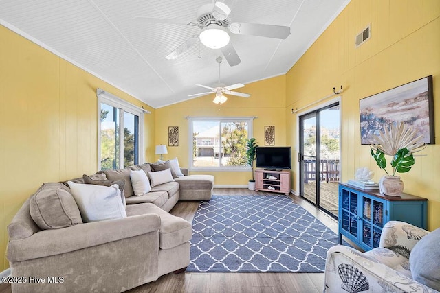 living area with ceiling fan, visible vents, lofted ceiling, and dark wood finished floors