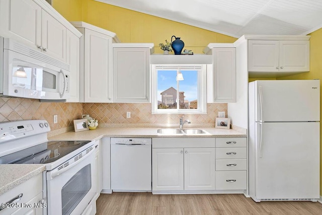 kitchen featuring a sink, white appliances, white cabinets, light wood finished floors, and vaulted ceiling