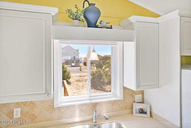 details with a sink, tasteful backsplash, and white cabinetry