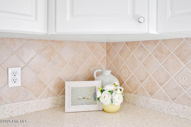 interior details featuring light stone counters and white cabinetry