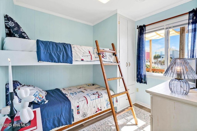 bedroom with crown molding and wood finished floors