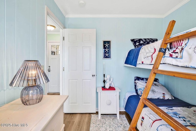 bedroom with light wood-style floors and ornamental molding