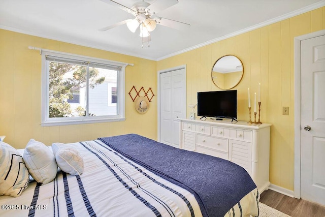 bedroom with a ceiling fan, wood finished floors, and ornamental molding