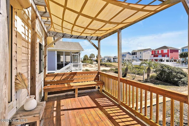 deck featuring a residential view, a pergola, and a sunroom