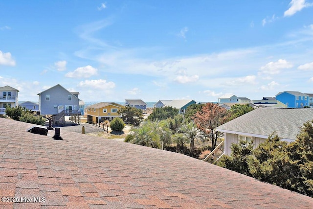 exterior space with stairway, a residential view, and a shingled roof