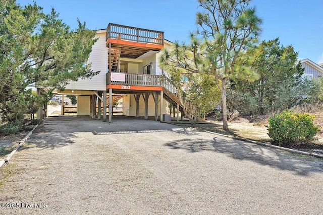 view of front of home with a carport, stairway, driveway, and central AC