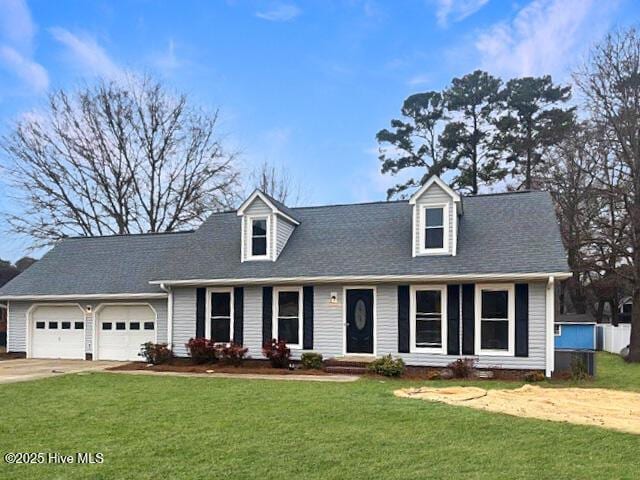 cape cod house with an attached garage, concrete driveway, a front yard, and roof with shingles