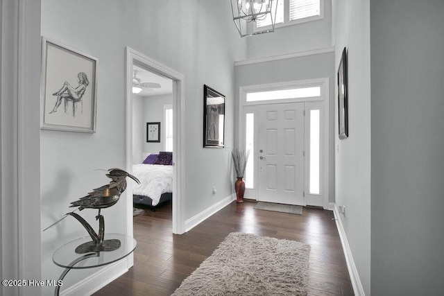 entryway with a high ceiling, dark wood-style floors, and baseboards