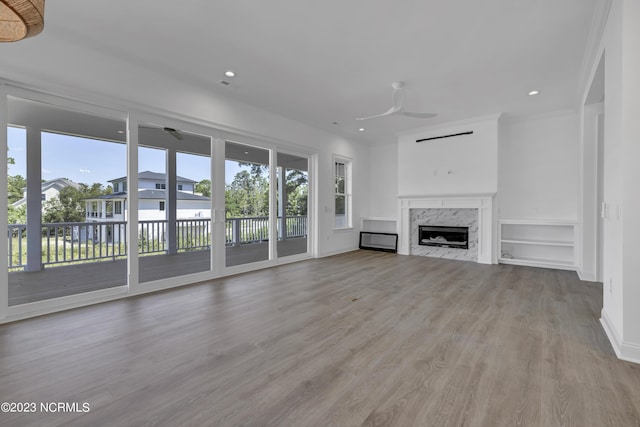 unfurnished living room featuring ornamental molding, a ceiling fan, recessed lighting, light wood-style floors, and a fireplace