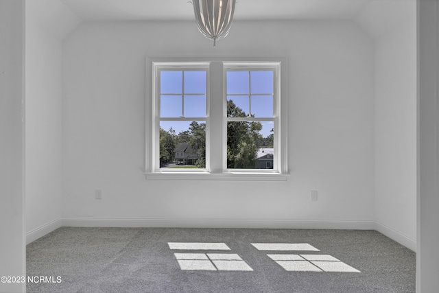 carpeted empty room with baseboards and lofted ceiling