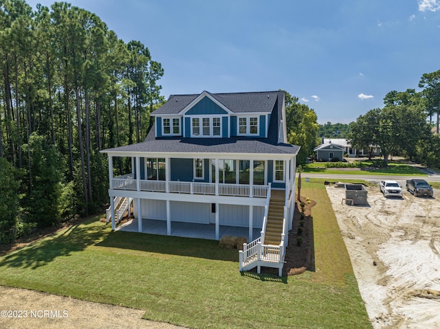 view of front facade featuring a front lawn, roof with shingles, stairs, and a patio area