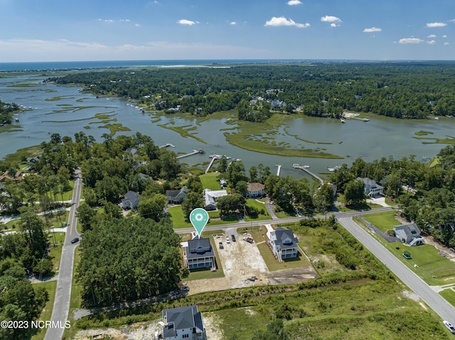 birds eye view of property featuring a forest view and a water view