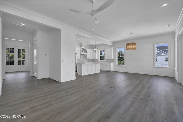 unfurnished living room featuring baseboards, a ceiling fan, ornamental molding, and dark wood finished floors