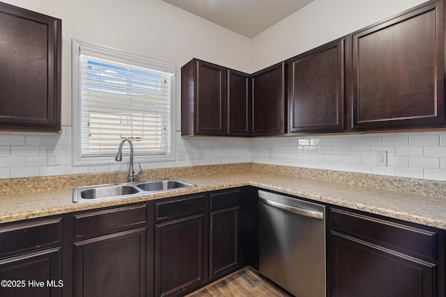 kitchen with dark brown cabinets, backsplash, dishwasher, wood finished floors, and a sink