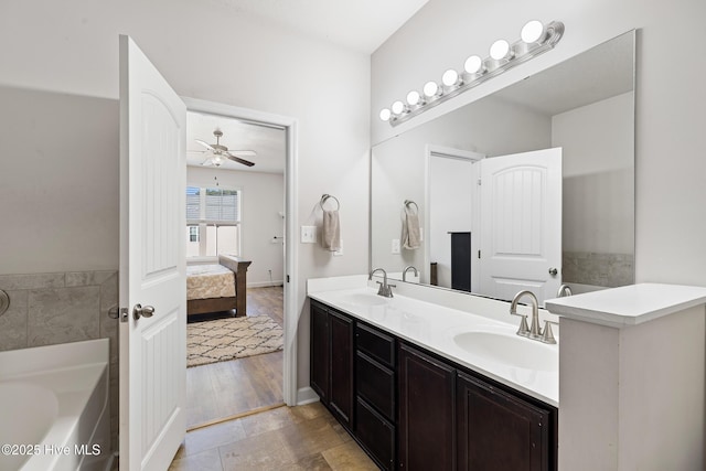 bathroom featuring a bath, a ceiling fan, ensuite bathroom, and a sink