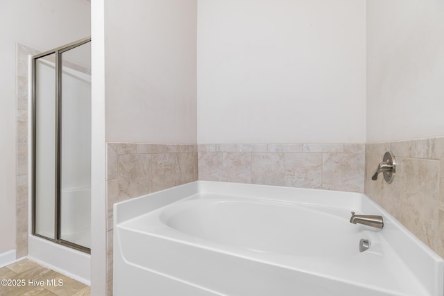 full bath featuring a shower stall and a garden tub