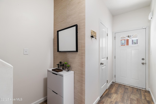 corridor featuring baseboards and wood finished floors