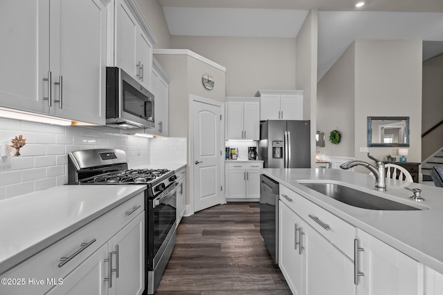 kitchen featuring a sink, appliances with stainless steel finishes, white cabinets, light countertops, and dark wood-style flooring