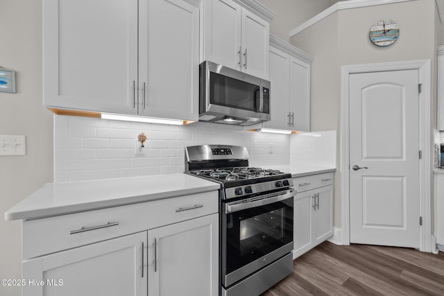 kitchen featuring white cabinetry, light countertops, dark wood finished floors, and appliances with stainless steel finishes