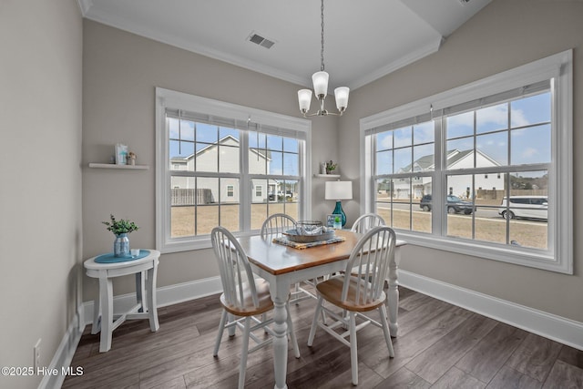 dining space with baseboards, a chandelier, dark wood finished floors, and ornamental molding