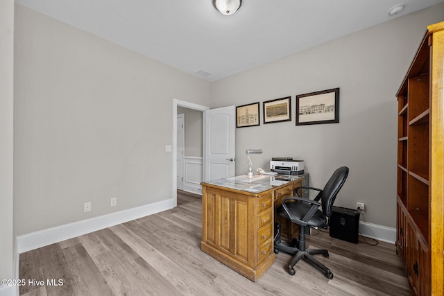 home office with light wood-type flooring, baseboards, and visible vents