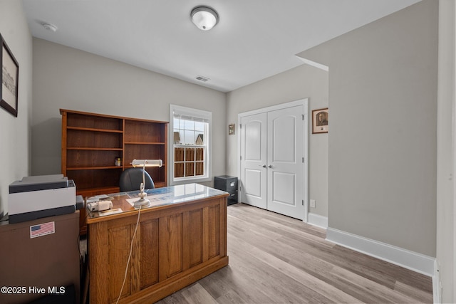 office featuring light wood-style flooring, baseboards, and visible vents