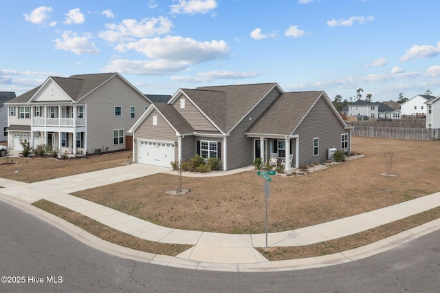 view of front of house featuring fence, a shingled roof, concrete driveway, a front lawn, and a garage