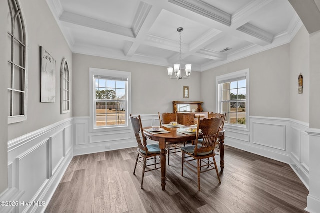 dining area featuring beamed ceiling, a healthy amount of sunlight, dark wood finished floors, and a chandelier