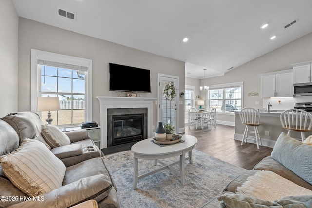 living room with lofted ceiling, recessed lighting, dark wood-style floors, and visible vents