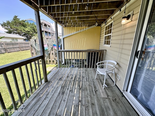 wooden deck with a lawn and fence