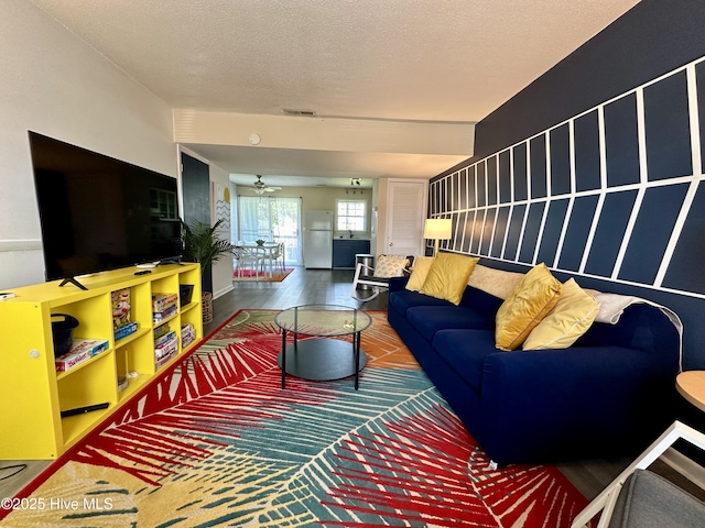 living room with wood finished floors, visible vents, and a textured ceiling