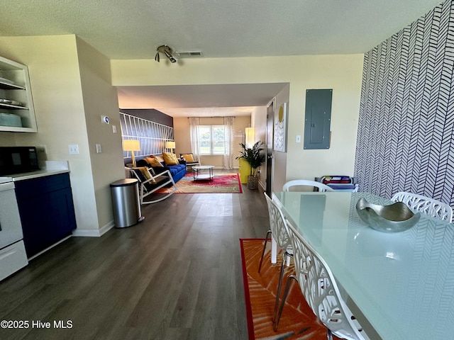 kitchen featuring baseboards, black microwave, dark wood finished floors, electric panel, and electric range